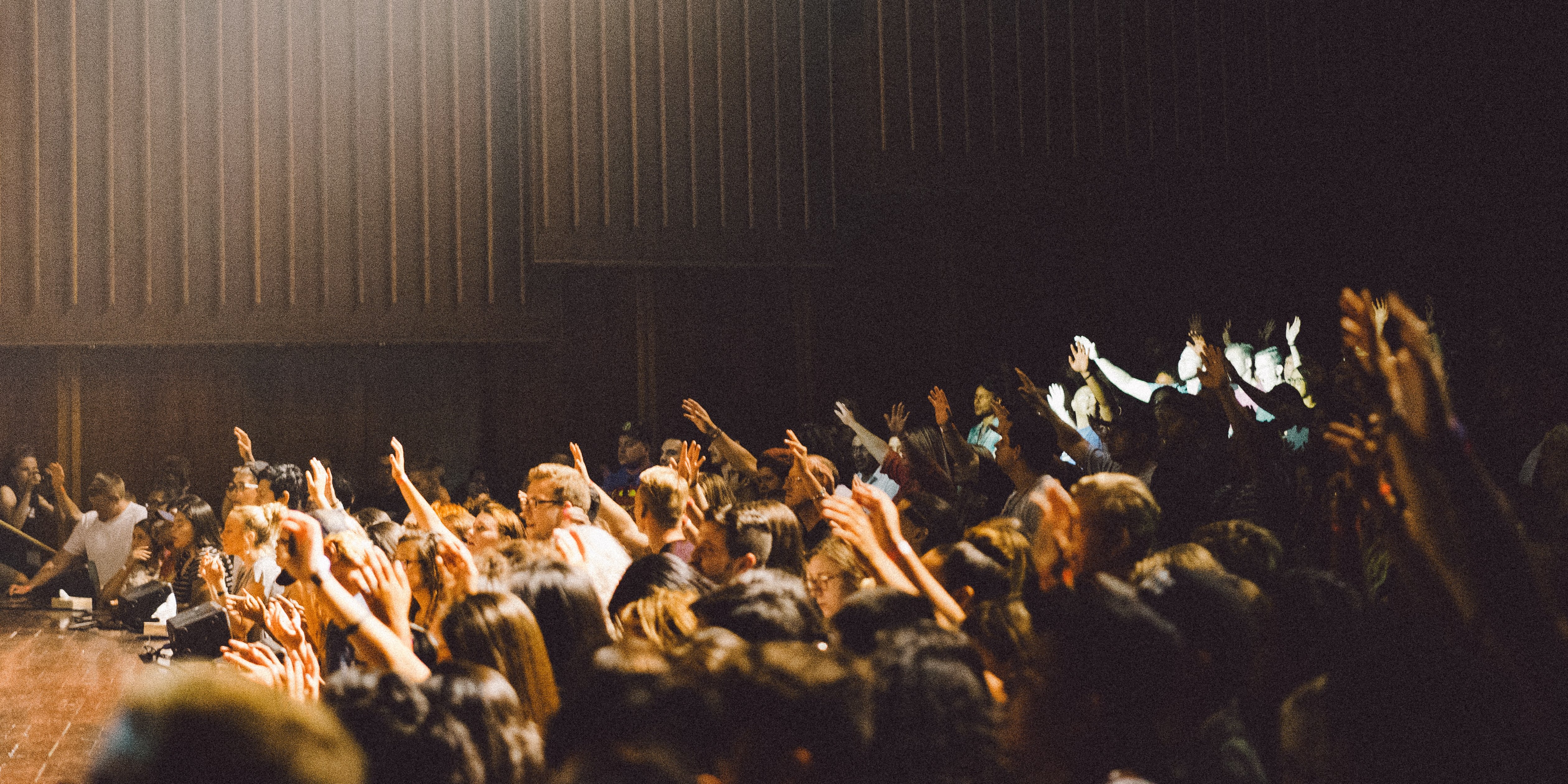 people in a huge meeting - hands up